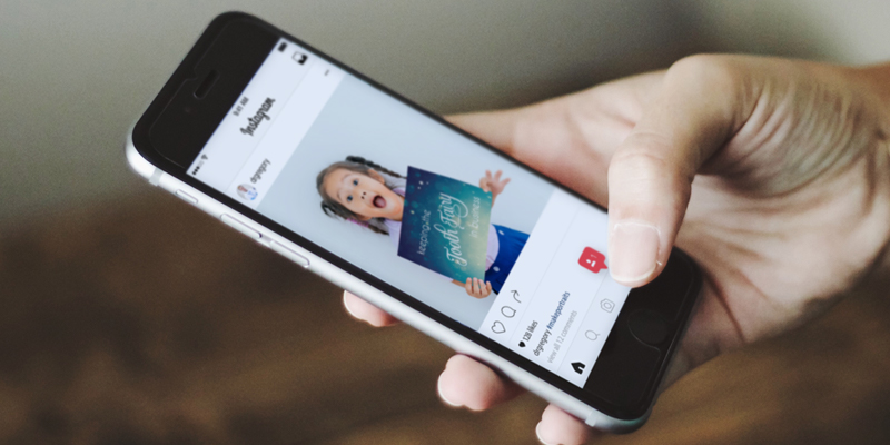 Person Holding Phone with Instagram Feed
